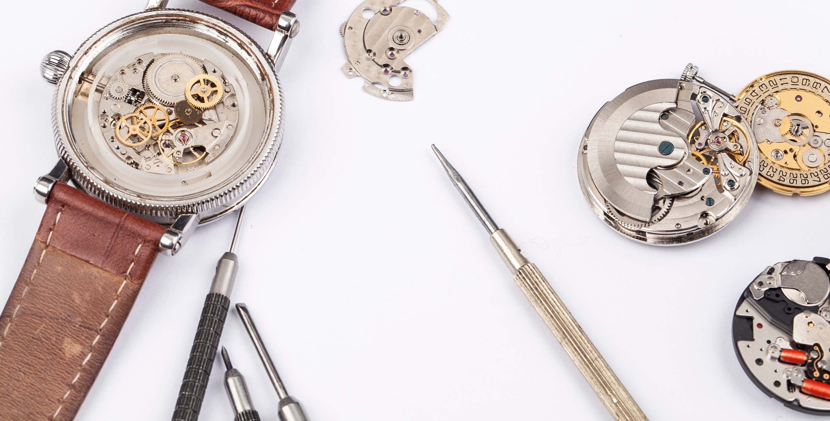 Precision watch tools, timepieces and repair notes arranged for a professional service