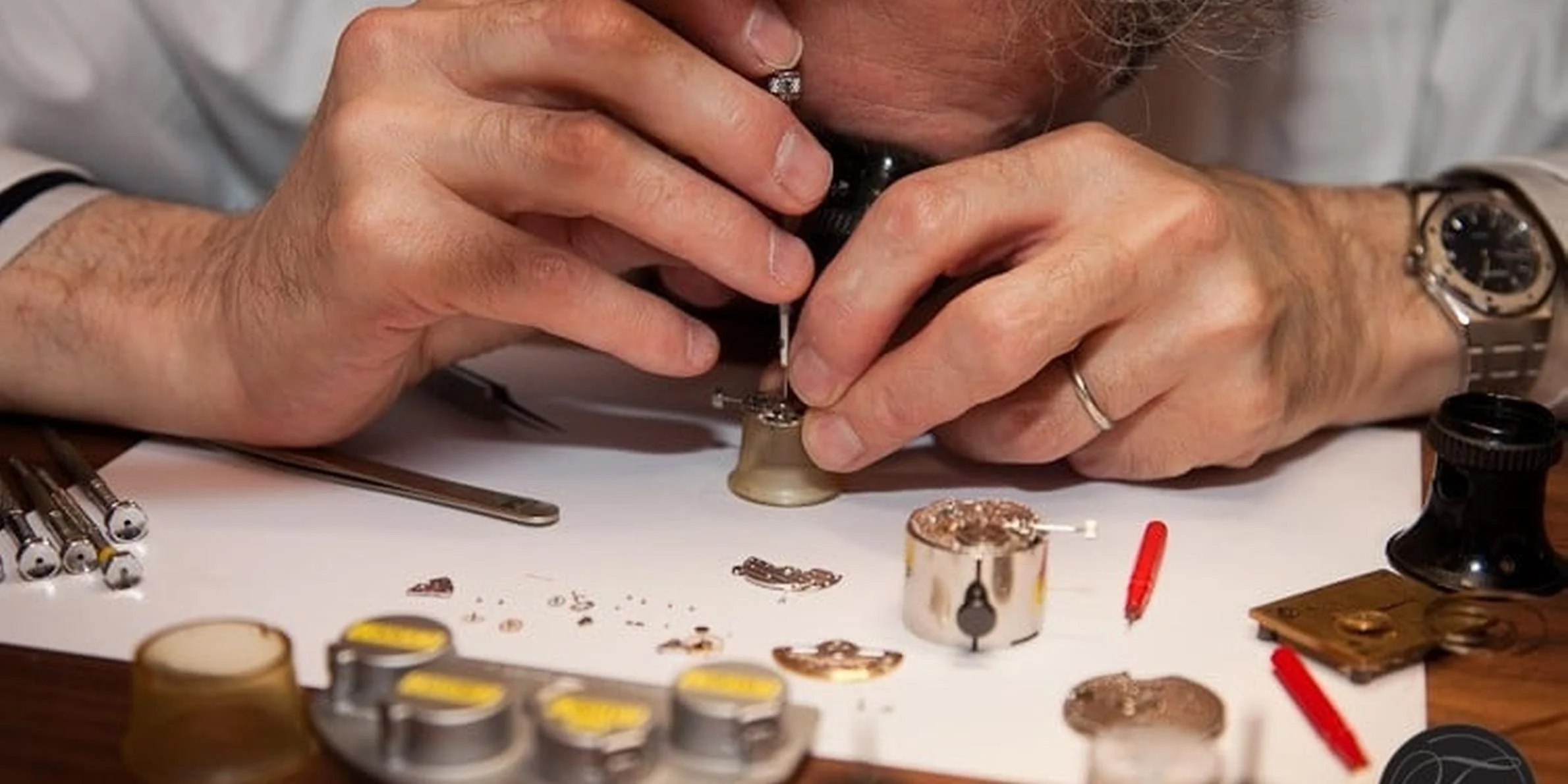 Watch repair notes, precision tools and components arranged for service planning